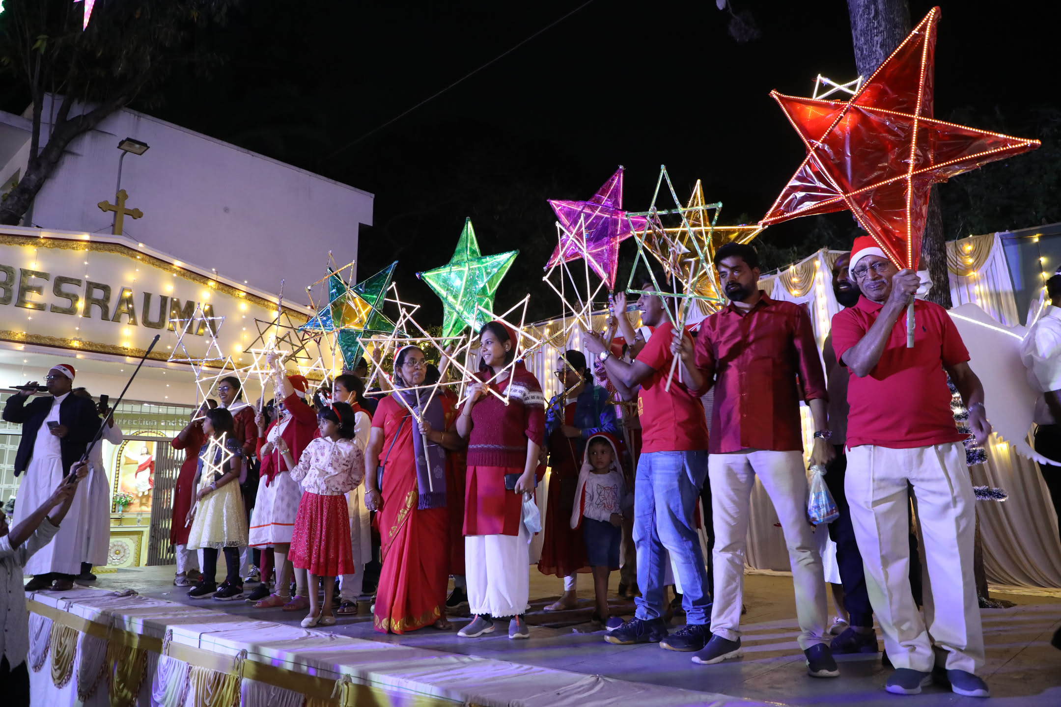 Parish choir performing beneath illuminated stars at Mega Carols