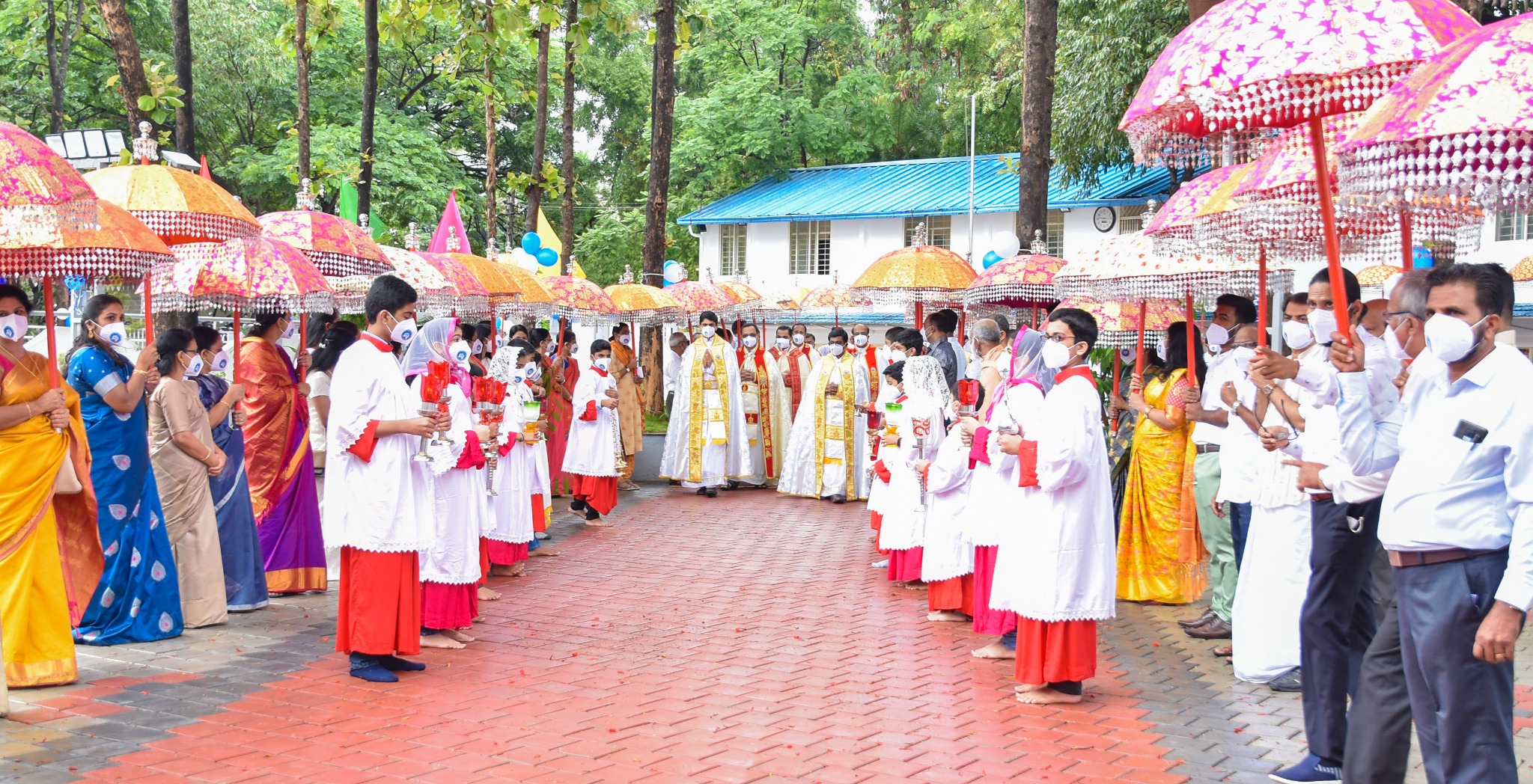 Liturgical procession beneath ceremonial umbrellas